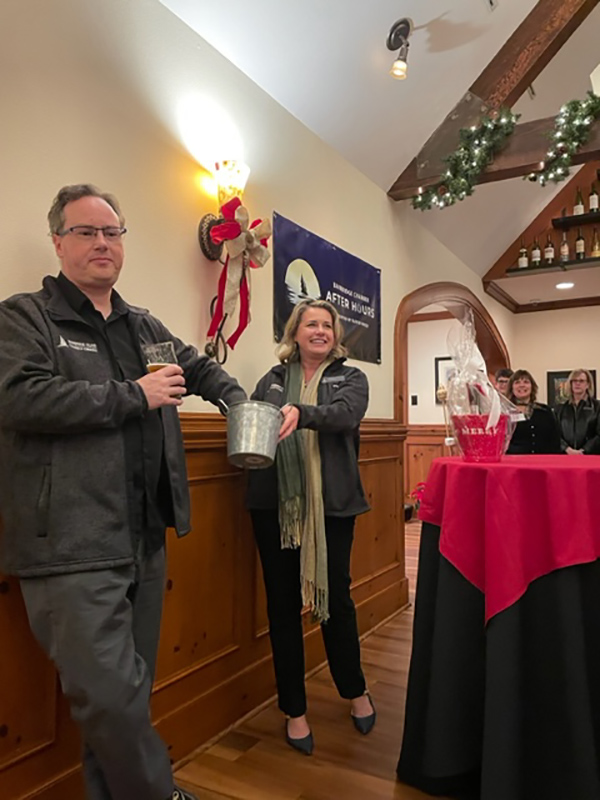 Bainbridge Chamber President/CEO Stefan Goldby and VP of Community Engagement Jessica Perkins pull the winners of the Holiday After Hours giveaway.