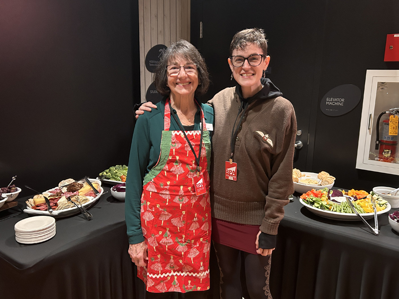Beth Ivey and Gus McGrath of Bainbridge Performing Arts in front of the delicious food they prepared for the Chamber's Holiday After Hours 2023